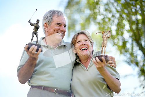Image of Senior couple, trophy or golfers with success for winning a sports tournament on golf course together. Excited, golfing celebration or happy mature winners hugging or smiling in a game in retirement