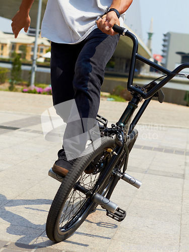 Image of Bicycle, wheel trick and man on street for sports, balance and action at urban skatepark. Closeup of person, bike stunt and cycling challenge in city for skill, fun performance and freedom outdoors