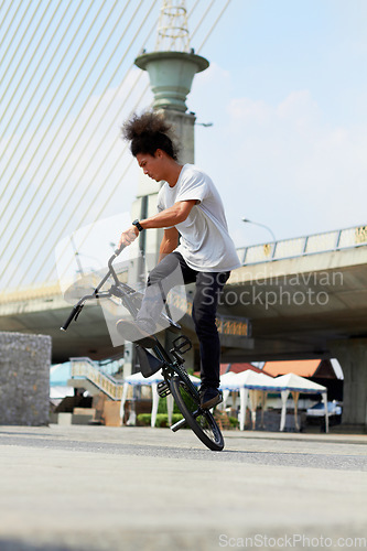 Image of Urban, trick and man jump with bicycle for sports, balance and action in city street. Gen z male person, cycling stunt and challenge of biker in town for skill, performance risk and freedom of motion