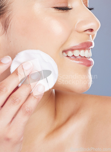 Image of Skincare, cotton and woman woman in studio for makeup removal, toner or hydration on grey background. Smile, beauty and asian lady wellness model with facial pad for cleaning or glowing skin routine