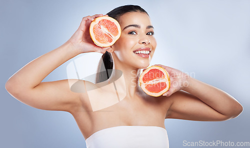 Image of Skincare, portrait and woman with grapefruit in a studio for a natural, organic or health face routine. Beauty, self care and female model with citrus fruit for a facial treatment by gray background.