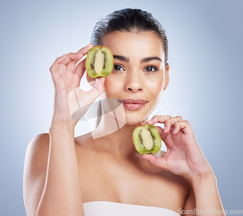 Image of Beauty, portrait and woman with kiwi in studio for a natural, organic or health face routine. Skincare, self care and female model with fresh fruit for facial dermatology treatment by gray background