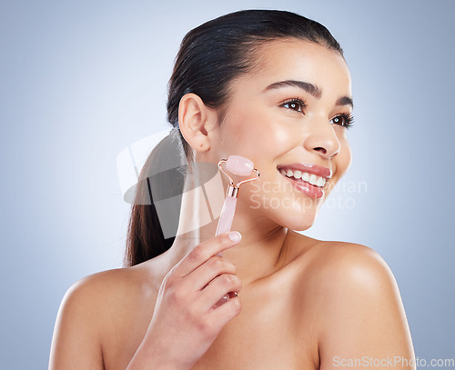 Image of Derma roller, skincare and asian woman in studio for anti aging, cosmetic or face massage on grey background. Rose quartz, facial and lady wellness model with luxury, beauty or lymphatic drainage