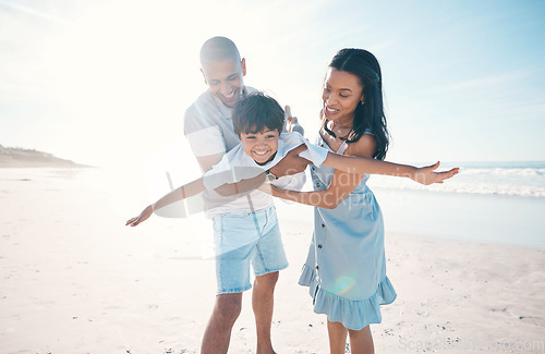 Image of Beach, happy and parents flying their child on the sand by the ocean on a family weekend trip. Love, smile and boy kid holding and bonding with his young mother and father on tropical summer holiday.