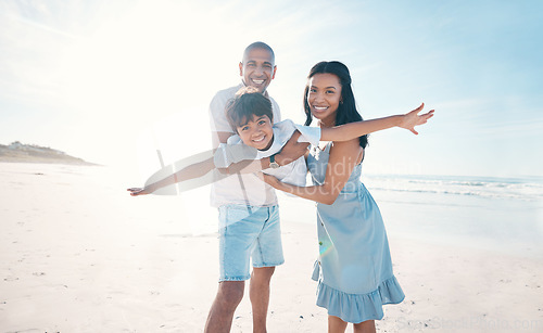 Image of Adventure, beach and parents holding their kid on the sand by the ocean on a family vacation. Happy, smile and boy child flying and bonding with hid young mother and father on tropical summer holiday