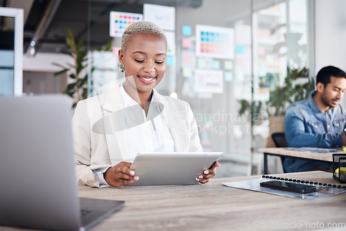 Image of Happy woman at desk in office with tablet, laptop and reading email at design agency. Business, smile and African employee in coworking space with digital report in creative career at tech startup.