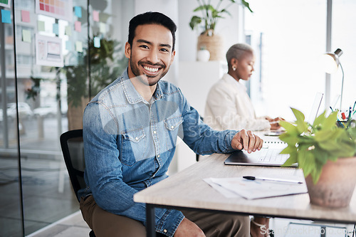 Image of Portrait of happy man at desk in coworking space with laptop, notes and work at design agency. Business, smile and computer, employee in office with confidence in creative career at tech startup job.