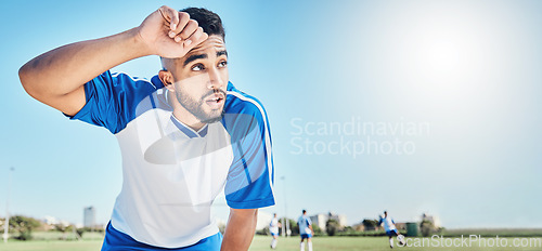 Image of Football player, tired and man sweating outdoor on a field for sports and fitness competition. Male soccer or athlete person on a break while exhausted from training workout with mockup banner space