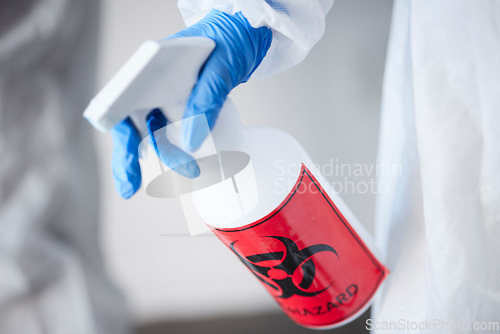 Image of Hazmat suit, spray bottle and gloves for biohazard, covid and stop virus for safety, protection or test in laboratory. Person, science and cleaning with chemical, liquid and ppe for bacteria in room