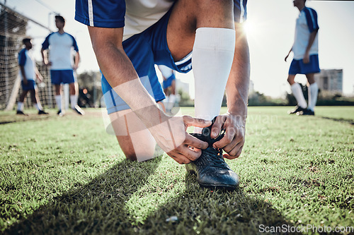 Image of Hands, man and tie shoes on soccer field, prepare for training or fitness games. Closeup, football player or athlete getting ready with sneakers lace in sports, competition and contest on grass pitch
