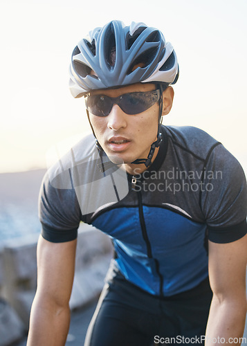 Image of Man, mountain and cycling outdoor with sunglasses, helmet and speed for training, exercise and health in summer. Young cyclist athlete, focus and vision for race, performance and workout in sunshine