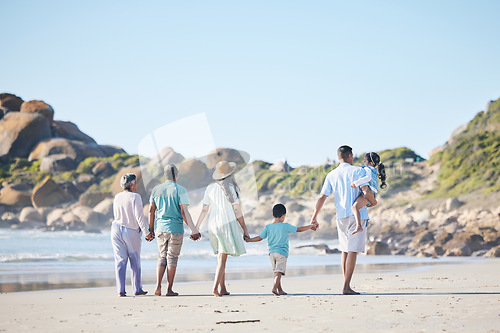 Image of Beach, walking and grandparents, parents and children by sea for bonding, quality time and relax in nature. Family, travel and back of mom, dad and kids by ocean on holiday, vacation and adventure