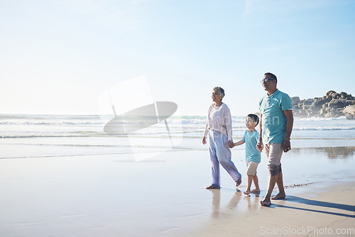 Image of Beach, walking and senior couple with boy for bonding, quality time and relaxing in nature. Family, travel and happy elderly man and woman with child by ocean on holiday, vacation and adventure