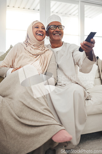 Image of Relax, muslim and watching tv with old couple on sofa for streaming, movie and funny. Television, smile and happy with senior man and woman in living room at home for comedy, retirement and lounge