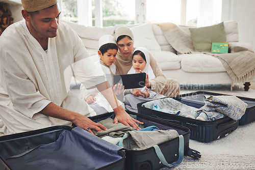 Image of Travel, packing and Muslim family with suitcase in living room for holiday, vacation and religious trip. Home, luggage and parents and children with tablet and bag for journey, adventure and tourism