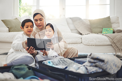 Image of Travel, tablet and Muslim family with suitcase packing for holiday, vacation and religious trip. Home, luggage and mom with kids on digital tech and clothes in bag for journey, adventure and tourism