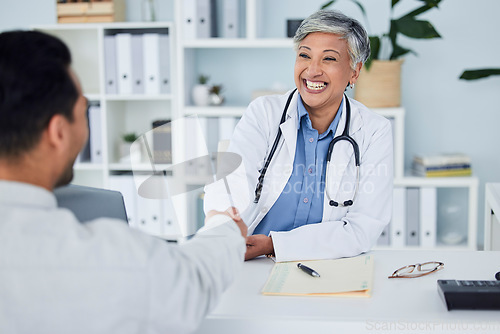 Image of Happy woman, doctor and handshake for meeting, hiring or partnership in consultation at the hospital. Senior female person, medical or healthcare professional shaking hands in interview or recruiting