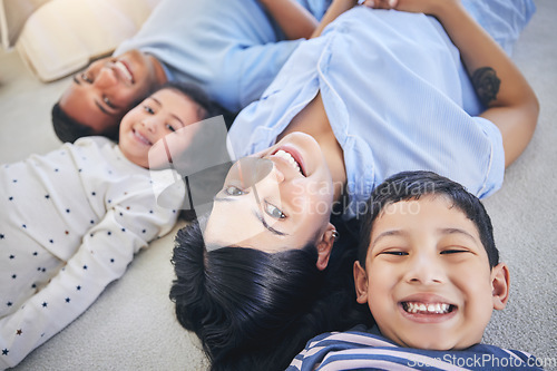 Image of Top view, portrait and happy family on a floor relax, bond and playing in their home on the weekend. Face, smile and above children with young parents in a bedroom with love, fun and chilling