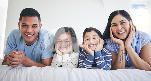 Image of Happy family, portrait and kids with parents on a bed relax, excited and bonding in their home. Face, smile and children with mother and father in bedroom for weekend, chilling and waking up playful