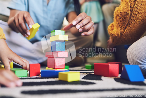 Image of Hands, building blocks and color, learning and development with people at home playing games with toys. Relax on living room floor, parents and children with education activity, family and bonding