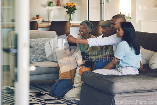 Image of Family, kids and watching tv on sofa with grandparents, parents or remote control for choice in home. Men, women and children for television, movie or streaming video on lounge couch, smile and house