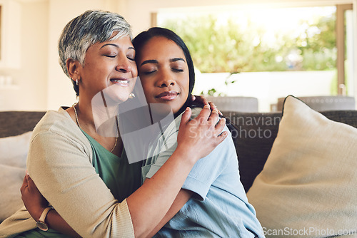 Image of Family, senior woman hugging her daughter and love with people sitting on a sofa in the home living room during a visit. Smile, trust or comfort with an elderly female parent embracing an adult child