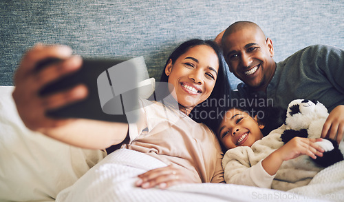 Image of Family selfie, parents and child in a bed together with love, care and security or comfort. Woman, man and kid relax with a happy smile for quality time, memory or profile picture in a home bedroom