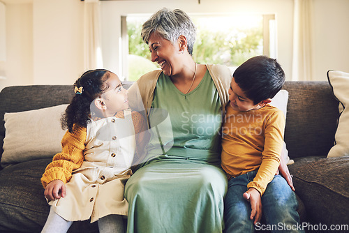 Image of Laughing, grandmother or happy kids on a sofa with love enjoying quality bonding time together in family home. Smile, affection or funny senior grandparent hugging children siblings on house couch