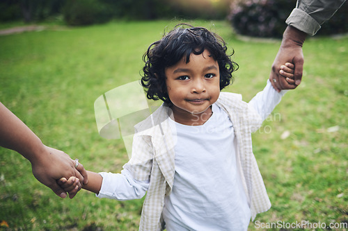 Image of Nature, cute and boy child holding hands with his parents while walking in an outdoor park. Sweet, young and portrait of a kid with his mother and father in a green garden with love, care and support