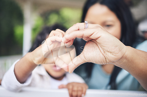 Image of Mother, child and heart hands for love, care or compassion together in the outdoors. Mom and little kid putting hand for loving emoji, like or sign gesture for support, trust or parenting outside