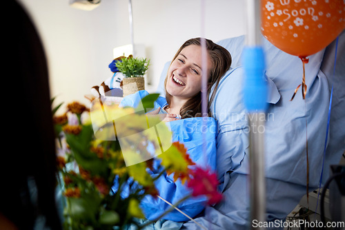 Image of Hospital, sick patient and visitor with flowers at bed with a woman in recovery with support. Healthcare, medical insurance and person with bouquet, family and care with get well soon balloons