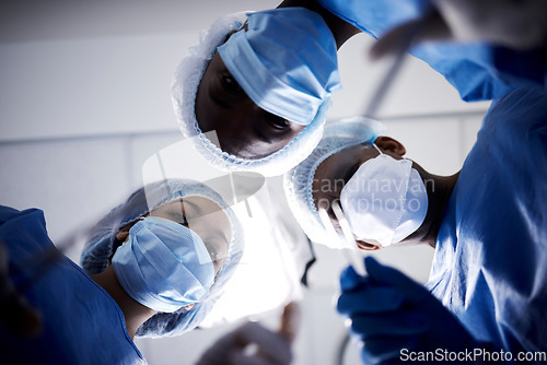 Image of Surgery, low angle or doctors with face mask, scissors or surgical procedure or healthcare in hospital clinic. Teamwork, medical safety tools or surgeons working in gloves helping in operating room