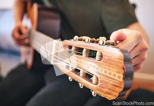 Image of Hands, person and tuning guitar for music, talent and creative skill in sound production. Closeup, musician and singer check notes of acoustic instrument for audio performance, solo artist or concert