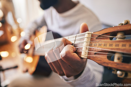 Image of Closeup, hands of man and guitar for music, live talent and creative skill of sound production in home studio. Musician, singer or artist playing notes on acoustic instrument in solo jazz performance