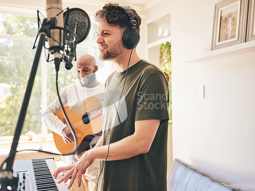 Image of Microphone, guitar and friends singing with piano in home studio together. Electric keyboard, acoustic instrument and recording band, creative music production and men live streaming on headphones.