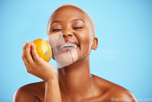 Image of Orange, funny and black woman with skincare, dermatology or cosmetics on a blue studio background. Female person, humor or model with citrus fruit, health or wellness with vitamin c or natural beauty