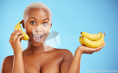 Image of Happy black woman, banana and diet for potassium, vitamin or fiber against a blue studio background. Portrait of African female person with bunch of yellow fruit for health and wellness on mockup