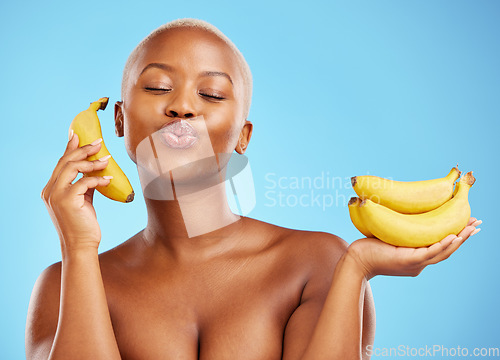 Image of Black woman, banana and diet for potassium, vitamin or fiber against a blue studio background. Face of calm African female person with bunch of yellow fruit for health and wellness on mockup space