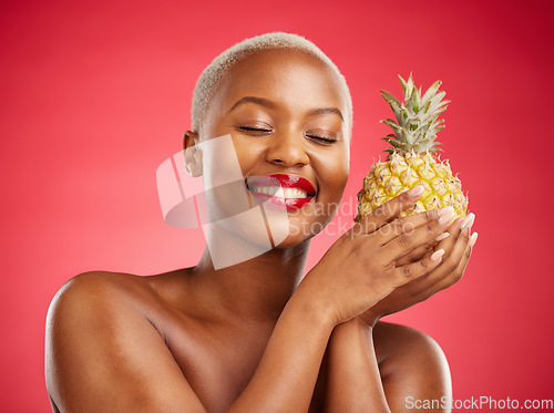 Image of Pineapple, beauty and face of a happy woman in studio for healthy food, diet or fruit. Black female model with makeup on red background for wellness glow, natural cosmetics and tropical skin care