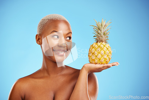Image of Black woman, pineapple and palm for diet, natural nutrition or health against a blue studio background. African female person smile in happiness holding organic fruit for vitamin, fiber or wellness