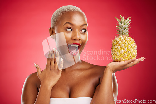 Image of Pineapple, surprise and beauty of a woman in studio for healthy food, diet or fruit. Black female model with makeup on red background for wellness glow, natural cosmetics and wow skin care benefits