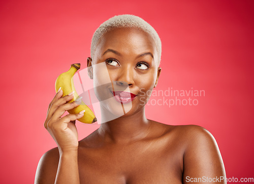 Image of Beauty, phone call and woman with a banana or acting angry, pretending and fake conversation on red background. Playful mobile communication, studio and girl with crazy and funny chat with fruit