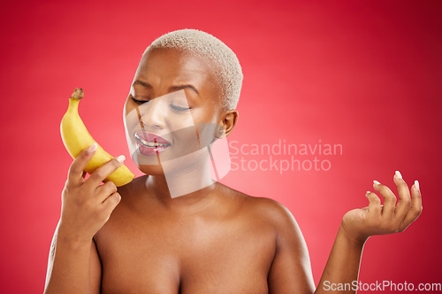 Image of Phone call, beauty and woman acting with a banana pretending, talking and fake conversation on red background. Playful mobile communication, skincare and girl in studio with funny or crazy fruit chat