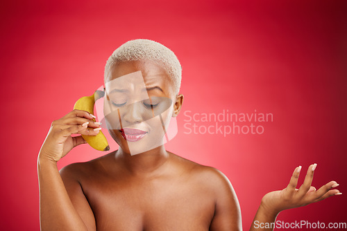 Image of Beauty, woman and talking to a banana phone or acting, pretending and fake call or conversation on red background. Playful communication, studio and portrait of girl with fruit or crazy chat