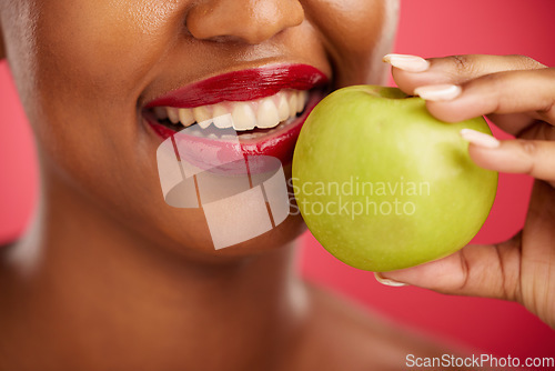 Image of Woman, mouth and apple for natural nutrition, diet or health and wellness against a red studio background. Closeup of female person smile with lipstick and organic fruit for vitamin, fiber or food