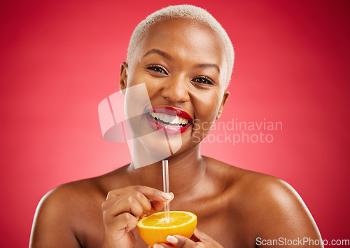 Image of Happy black woman, portrait and orange for vitamin C, diet or natural nutrition against a red studio background. African female person smile and drinking organic citrus fruit with straw on mockup