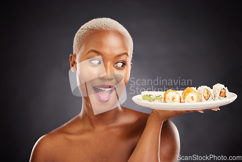 Image of Face, surprise and woman with sushi plate in studio for healthy eating, beauty or food. Excited black female model with makeup on dark background for wellness glow, wow diet or seafood advertising