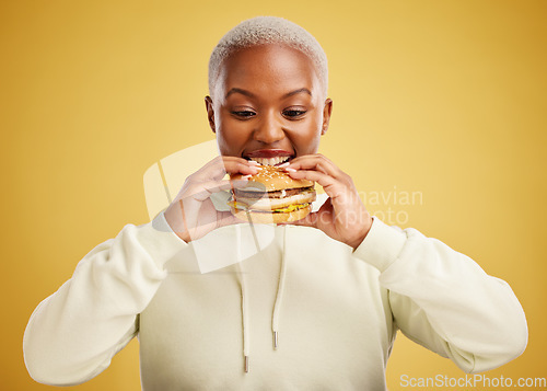 Image of Burger, eating and woman or happy student on a studio, yellow background for restaurant promotion or deal. Hungry and excited african person or customer experience with fast food and hamburger bite