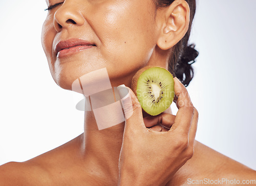 Image of Beauty, skincare and mature woman with kiwi in studio isolated on a white background. Food, fruit and natural model with nutrition for wellness, healthy diet and vitamin c for anti aging cosmetics.