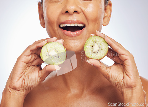 Image of Excited, face and senior woman with kiwi in studio isolated on a white background. Food, fruit and natural model with nutrition for skincare, diet and vitamin c for anti aging, cosmetics or health